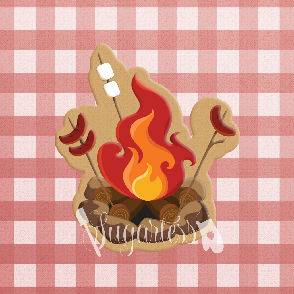 Sugartess custom cookie cutter in shape of campfire with marshmallow and sausage sticks.
