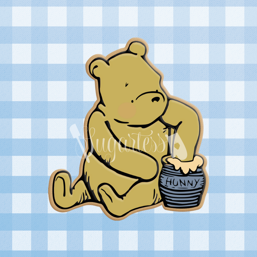 Sugartess custom cookie cutter in shape of classic Winnie The Pooh bear sitting with hand inside honey pot (design #2).
