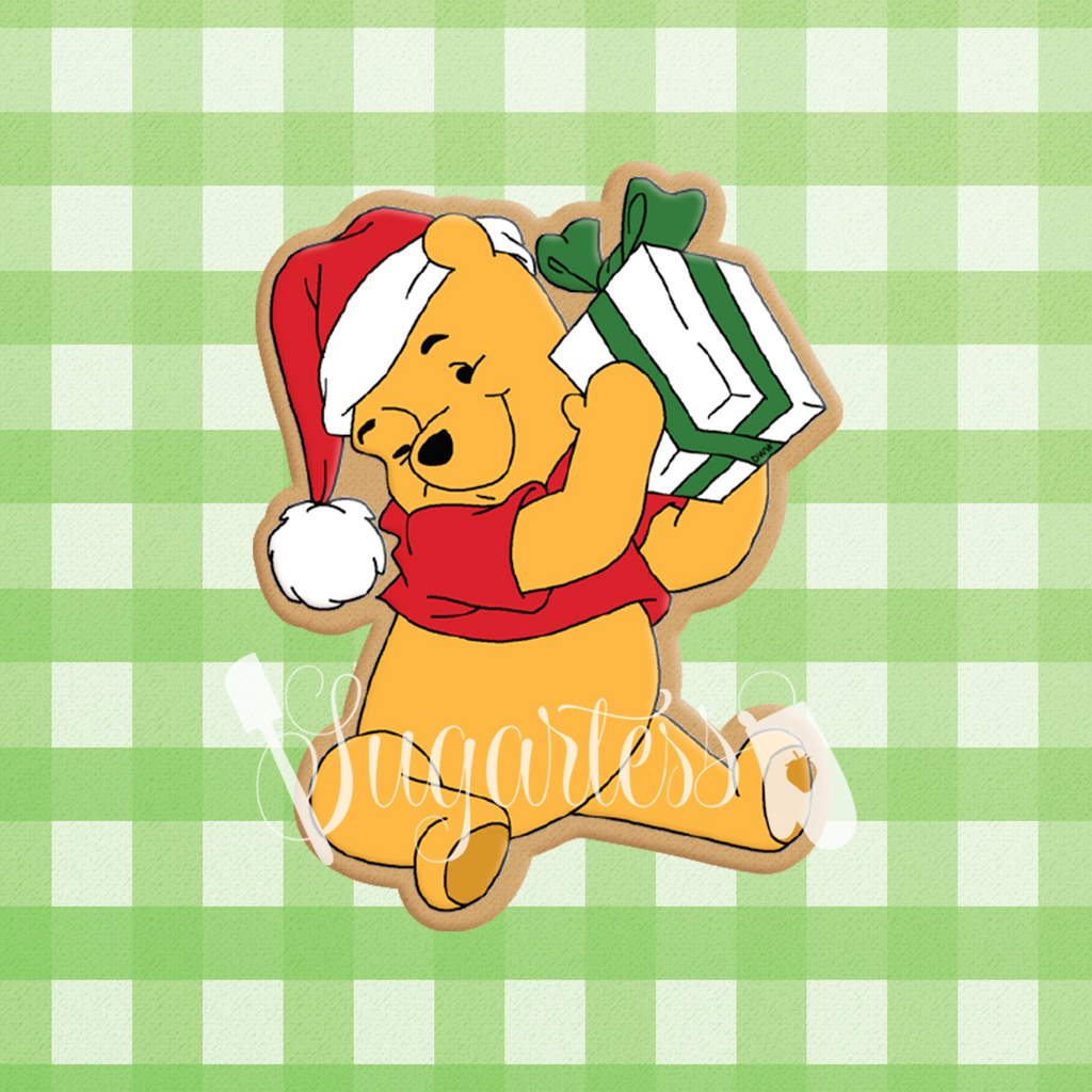 ugartess custom free cookie cutter in shape of holiday Winnie the Pooh sitting and holding a present.