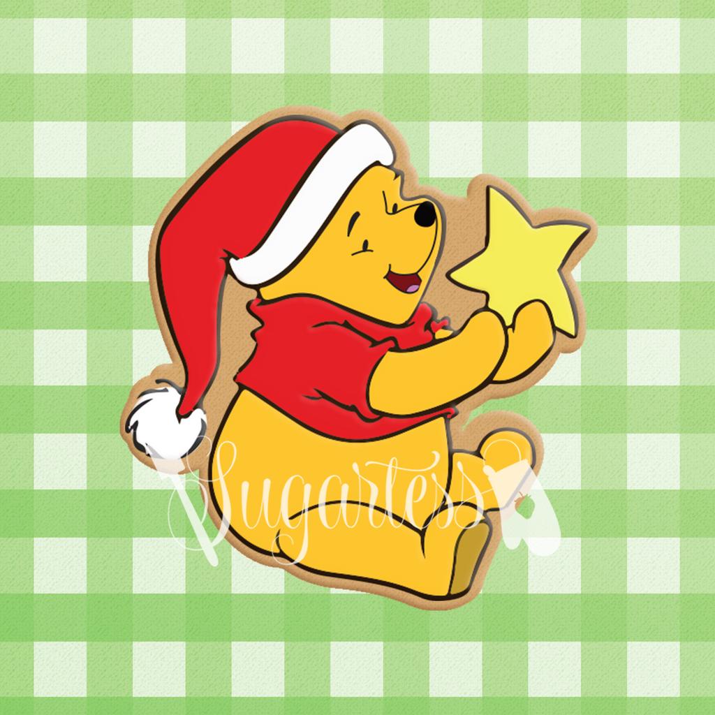 Sugartess custom free cookie cutter in shape of holiday Winnie the Pooh sitting and holding a star.