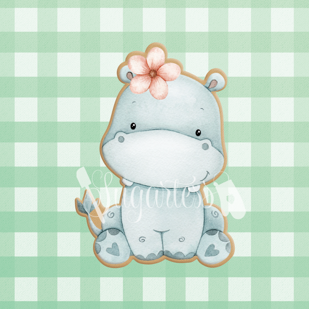 Sugartess cookie cutter in shape of a sitting baby girl hippopotamus with flower headpiece.