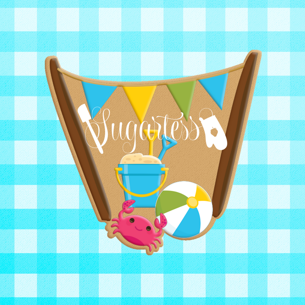 Sugartess custom cookie cutter in shape of beach scenery of flag poles, sand bucket, crab and beach ball.