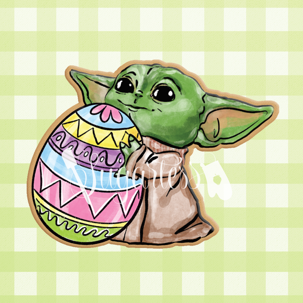 Sugartess custom cookie cutter in shape of baby Yoda holding an Easter egg.